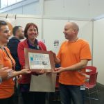 Yvon van SUP-school Domstad overhandigde een donatie die bij elkaar werd gespaard door zwerfafval uit de Utrechtse grachten te vissen.