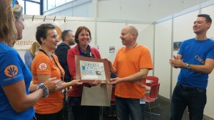 Yvon van SUP-school Domstad overhandigde een donatie die bij elkaar werd gespaard door zwerfafval uit de Utrechtse grachten te vissen.