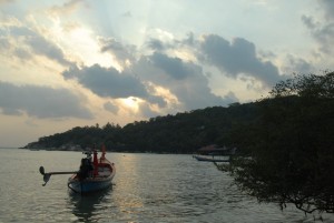 Zonsondergang met een typische Thaise longtail boot op de voorgrond